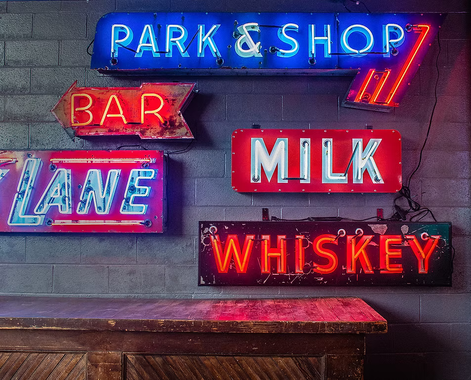 Park and Shop Bar Lane Milk Whiskey neon signs on brick wall